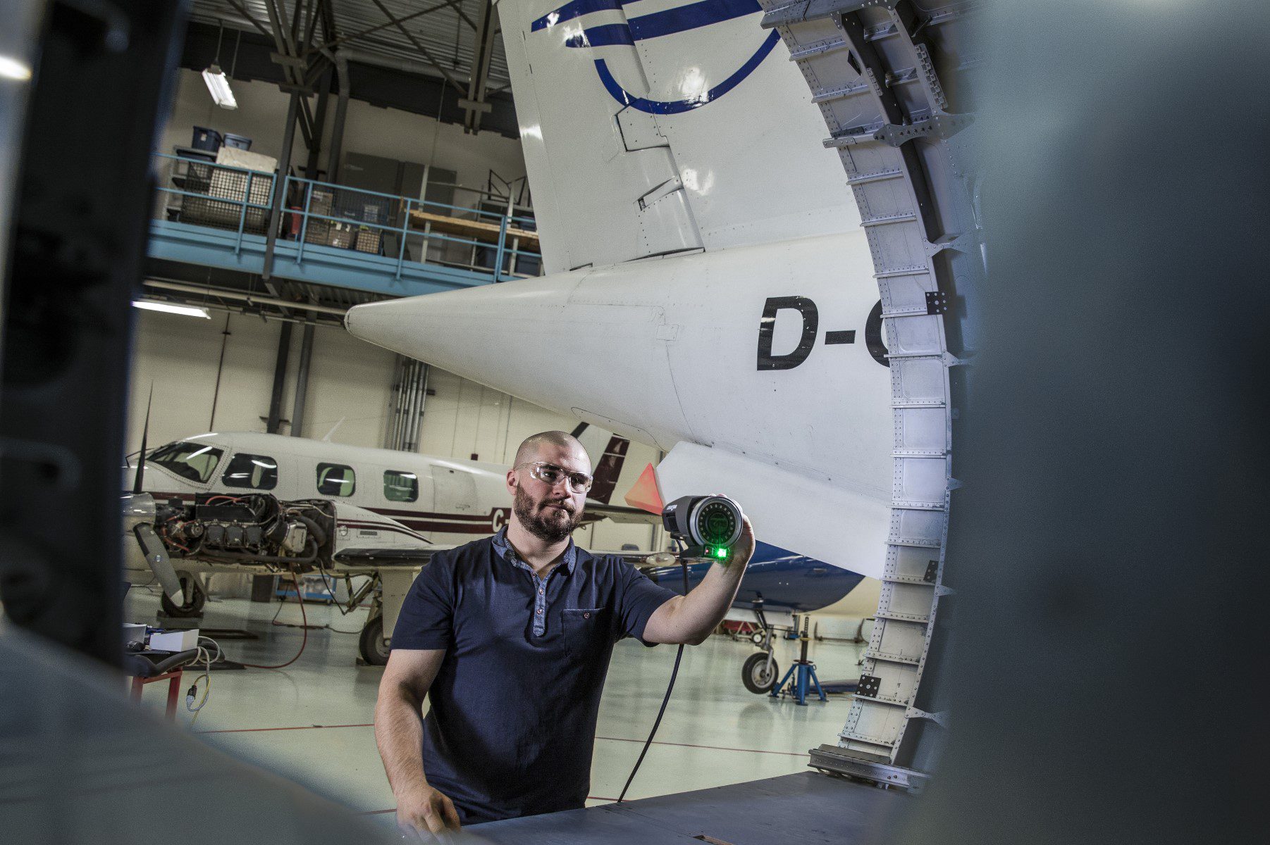 Image shows a technician using creafrom MaxShot 3D photogrammetry CMM in an airplanes hangar
