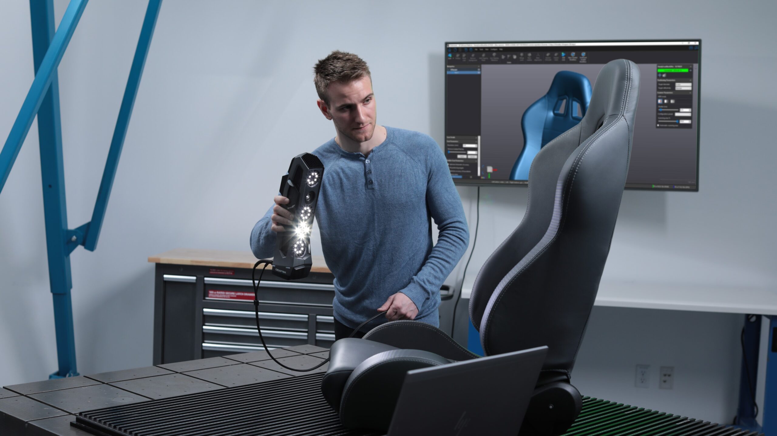 Image shows a young man scanning a racing chair with Creaform Go!SCAN 3D scanner