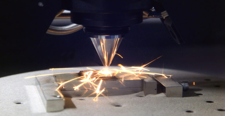 Detailed close-up of 3D printer printing a metal piece.
