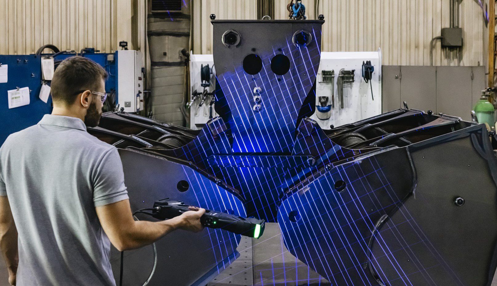 Image shows a man 3D scanning a large assembly with HandySCAN 3D MAX from Creaform